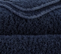 Zbliżenie na gęsty splot 700 GSM i zaokrąglony róg ręcznika Abyss & Habidecor.